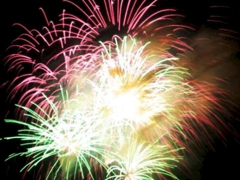 The image shows colorful fireworks exploding against a dark sky, creating a vibrant display of light and color at night.