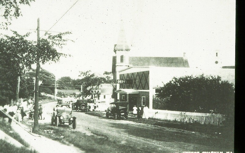 A vintage street scene with cars, people, and a building marked "Orphe" on Main Street in Chatham, MA, likely early 20th century.