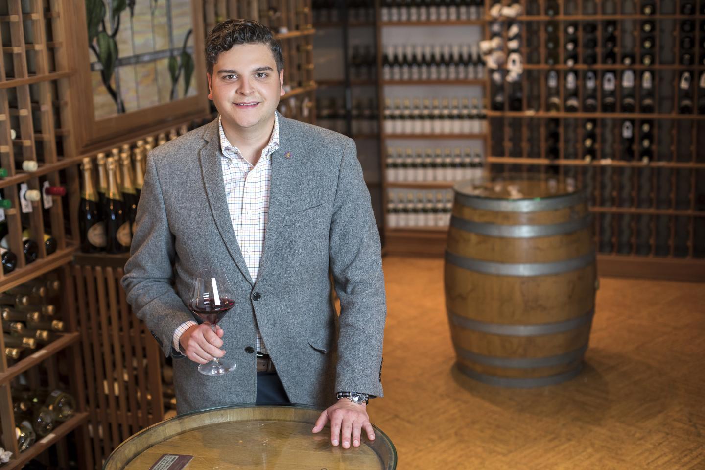 Sommelier in wine cellar holding a wine glass
