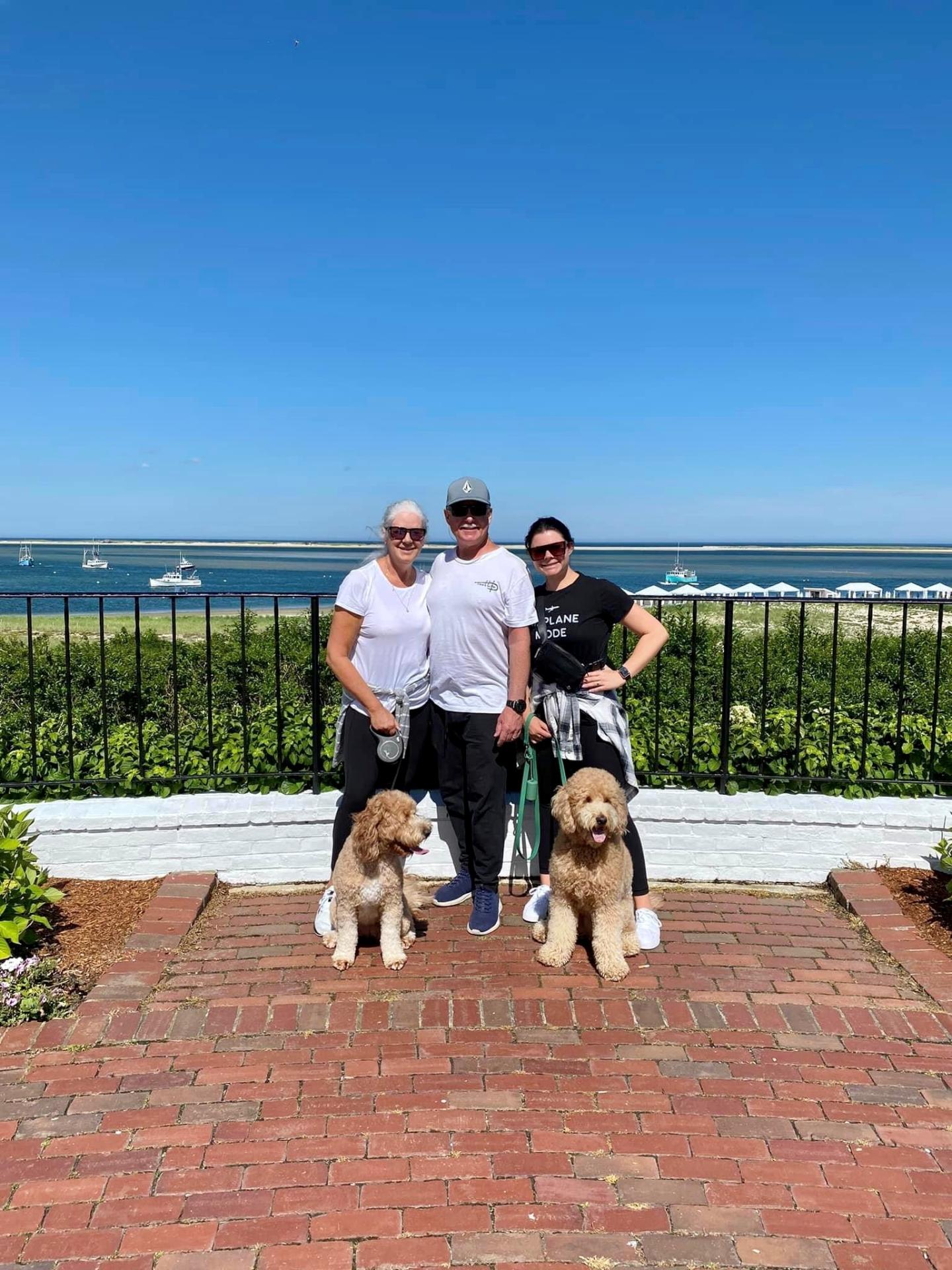 People posing with dog at the harbor