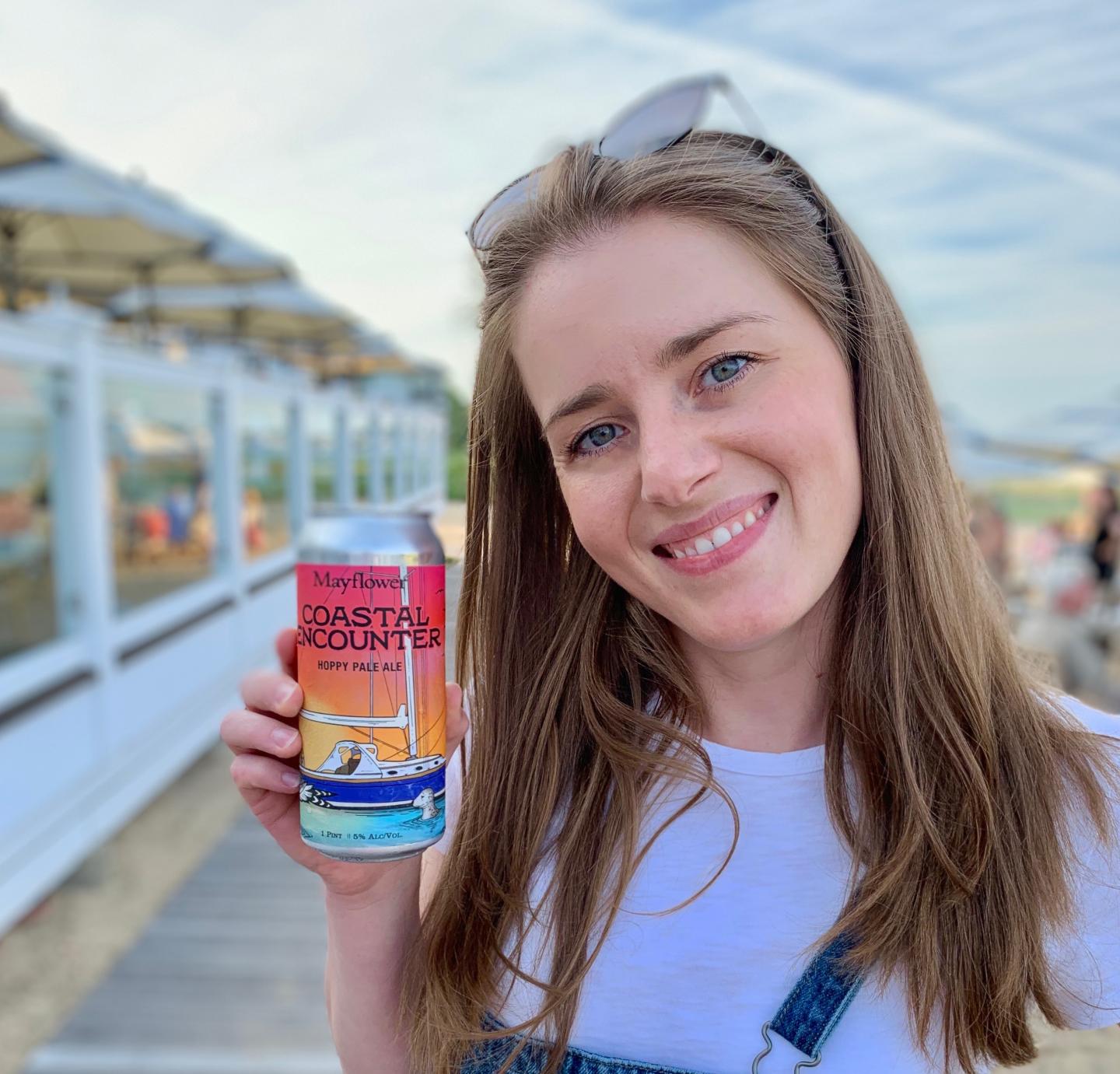 Women smiling and holding up the Coastal Encounter Beer.