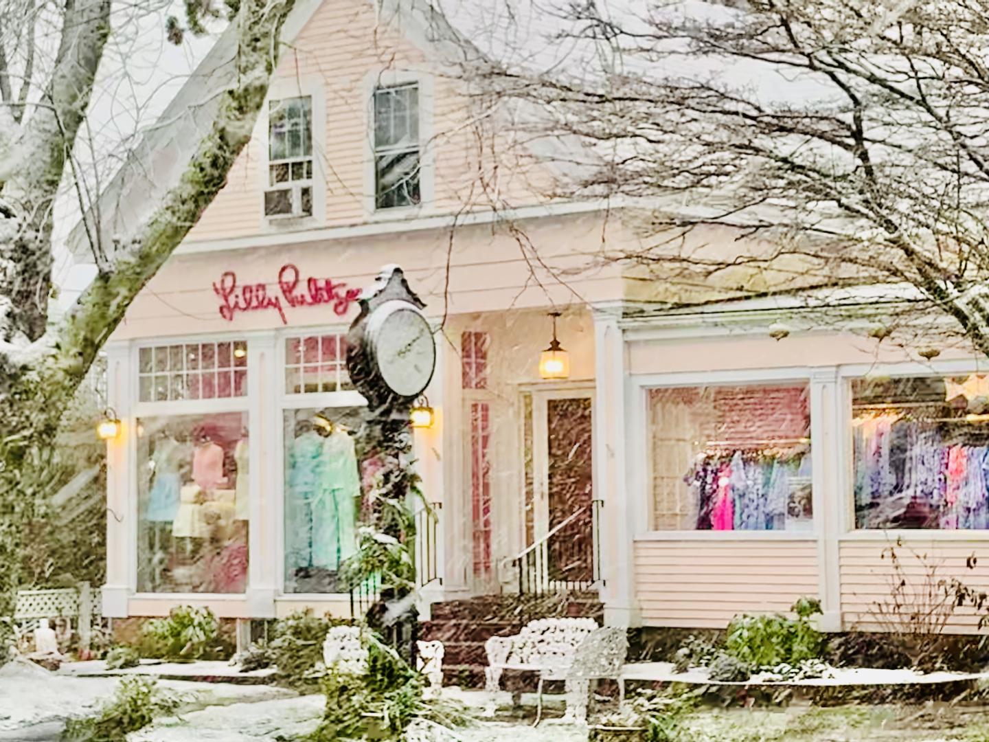 Snow-covered boutique with pastel exterior and colorful window displays.