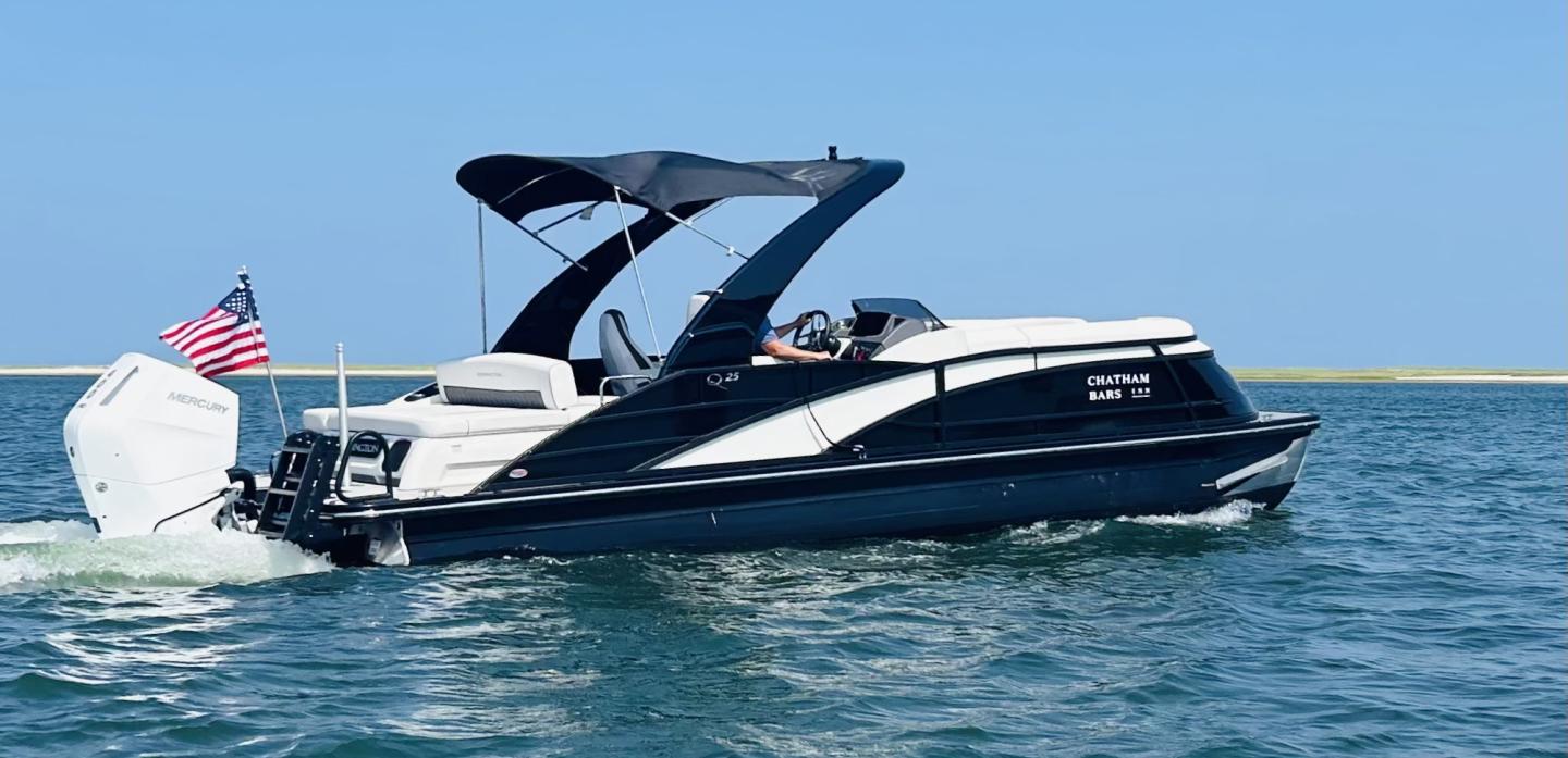 A sleek motorboat on calm water, with an American flag at the stern.