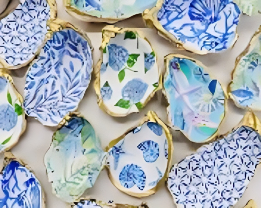 Colorful oyster shells with gold edges, decorated with blue floral patterns.