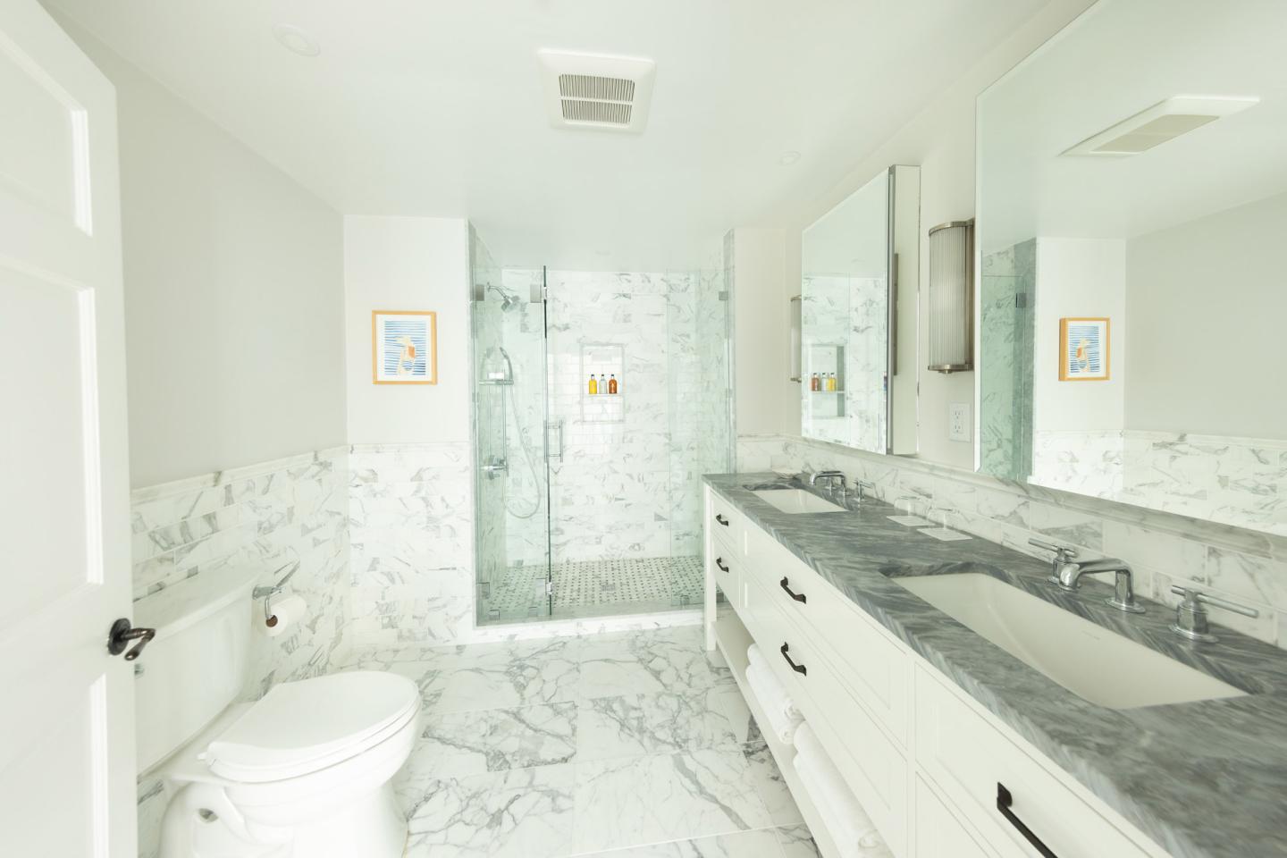 Elegant white bathroom with marble floor and countertop.