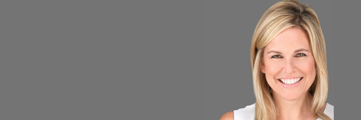 Smiling woman against a gray background.