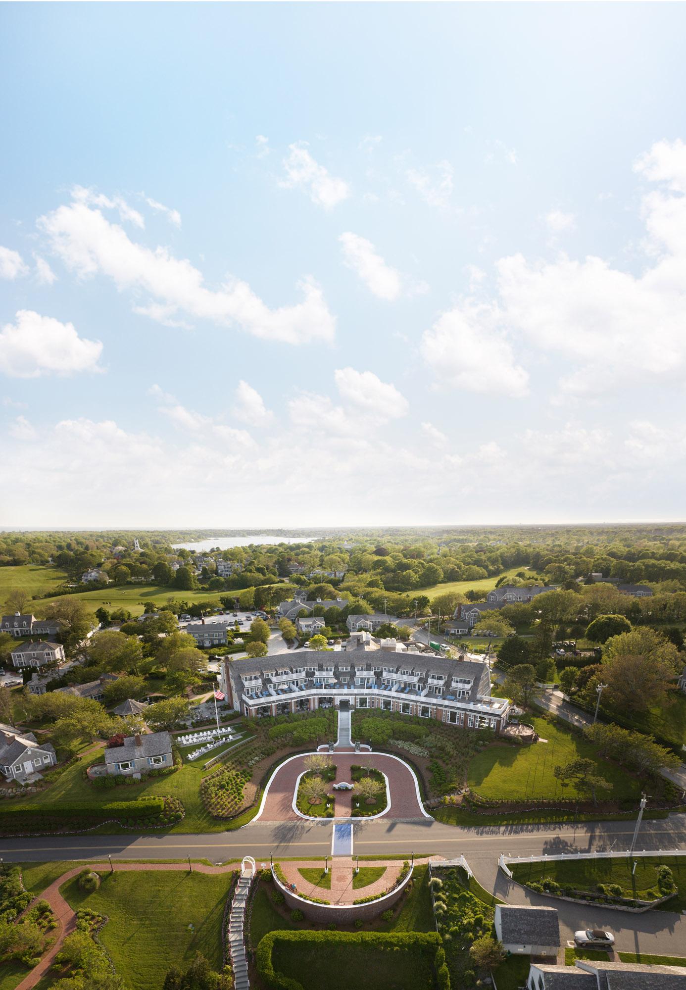 Aerial view of a sprawling estate with greenery and a clear blue sky.
