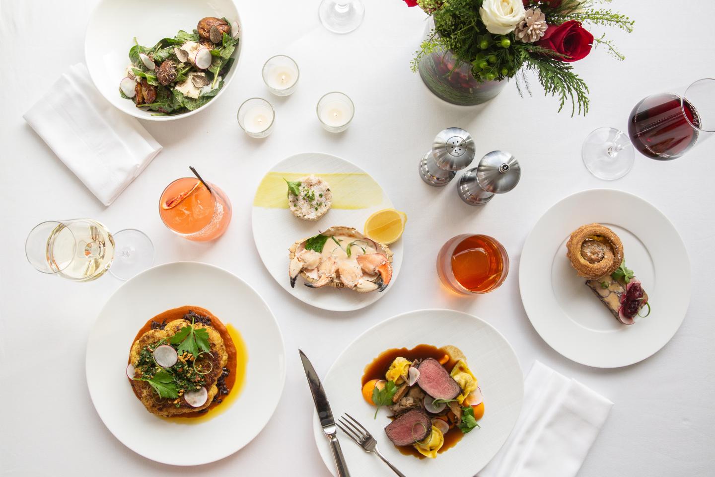 Elegant dining table with assorted gourmet dishes and drinks.