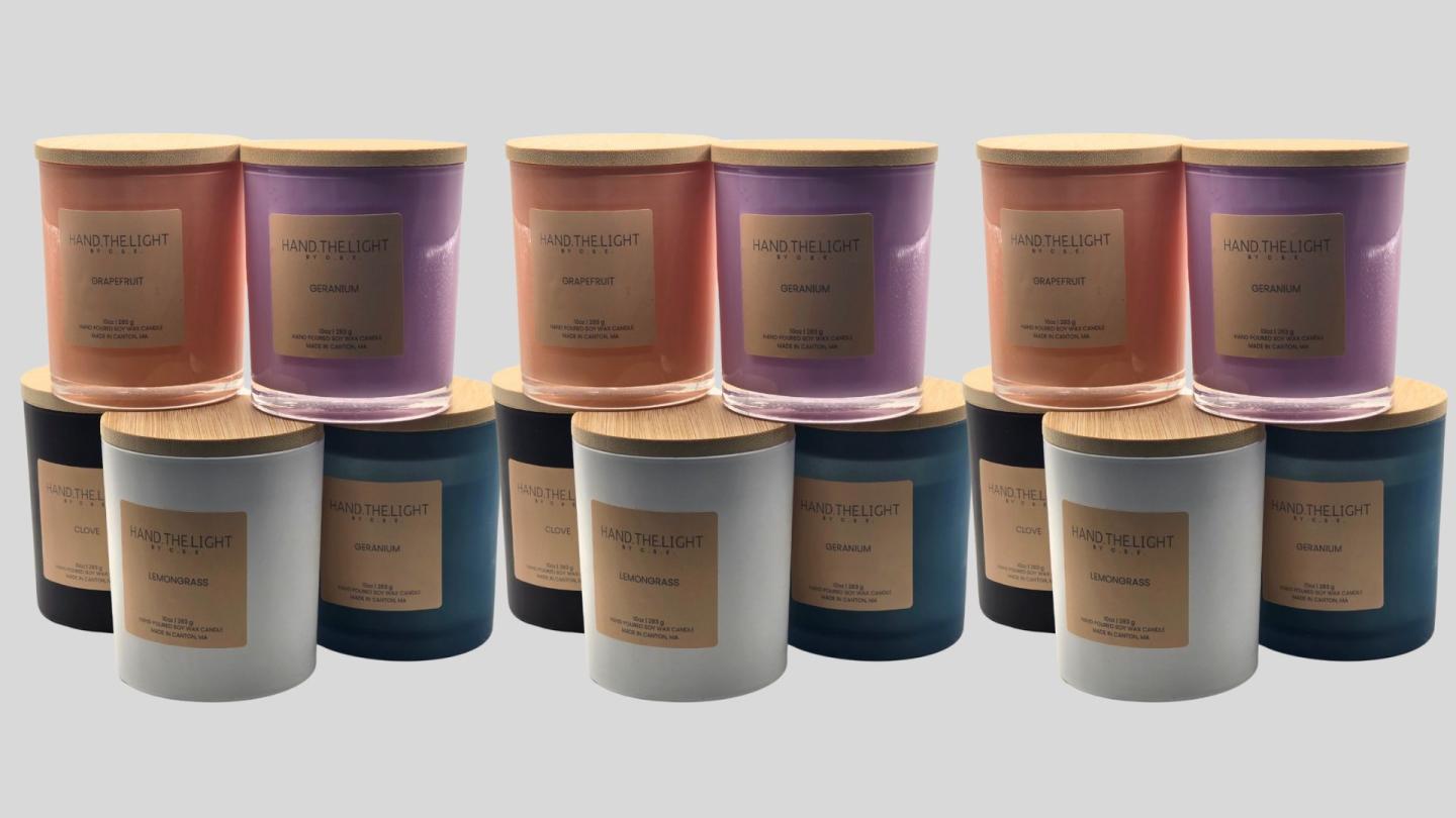 Colored candles with wooden lids arranged in rows.