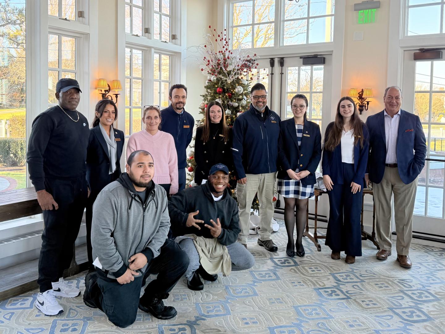 Group of people posing indoors with festive decorations.