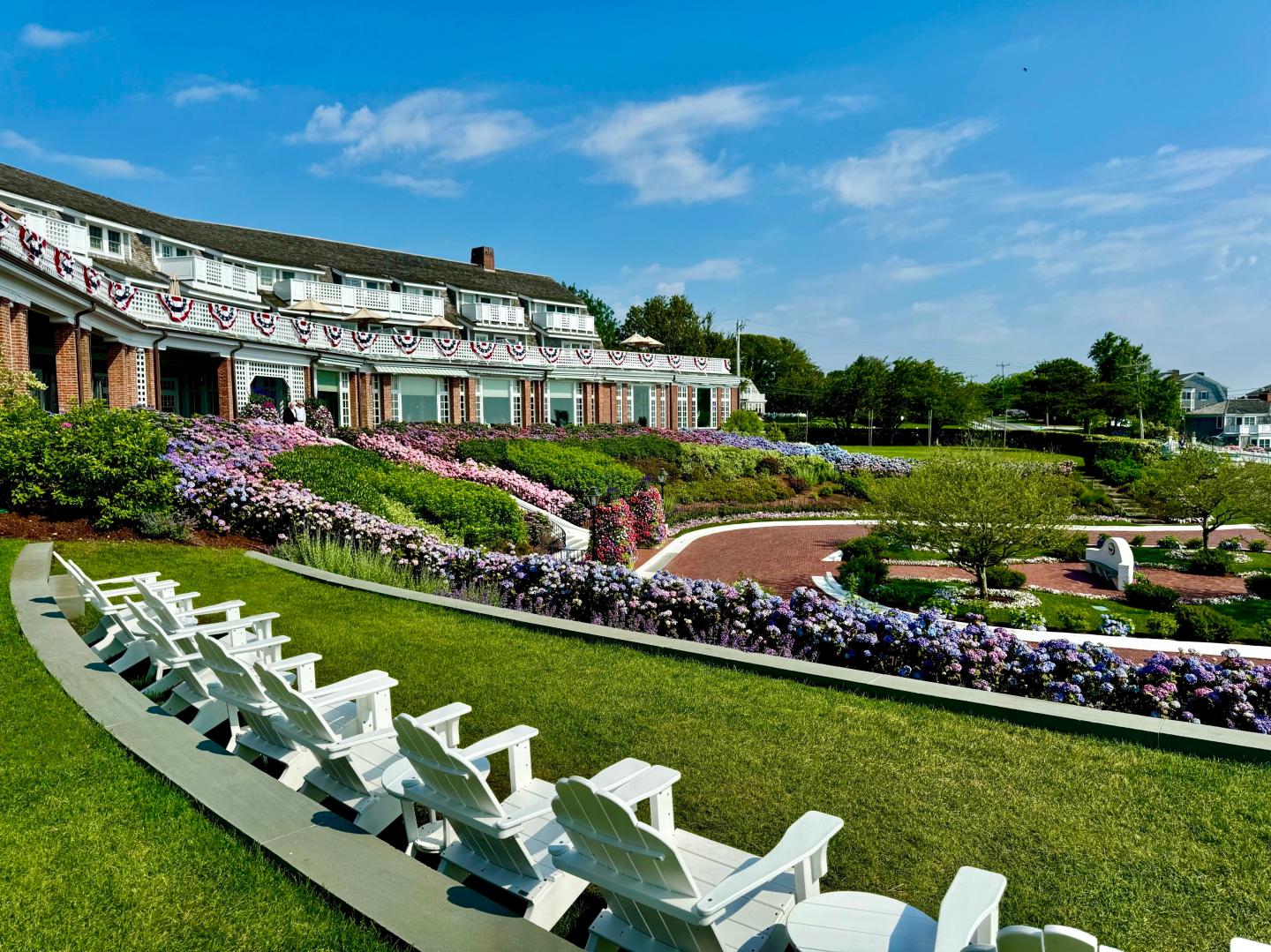 Lawn chairs facing a large building with decorated balconies and vibrant gardens.