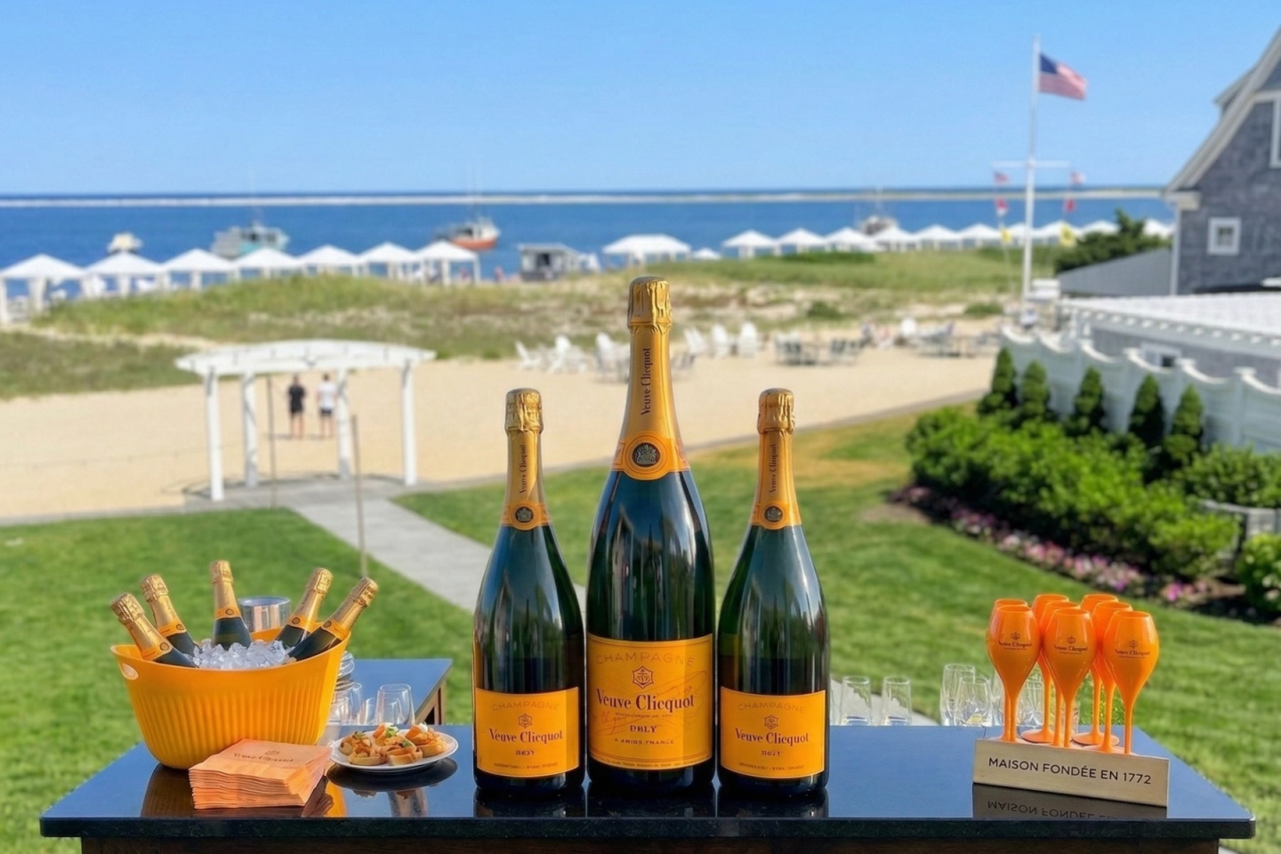 Champagne bottles on a table with a beach view.