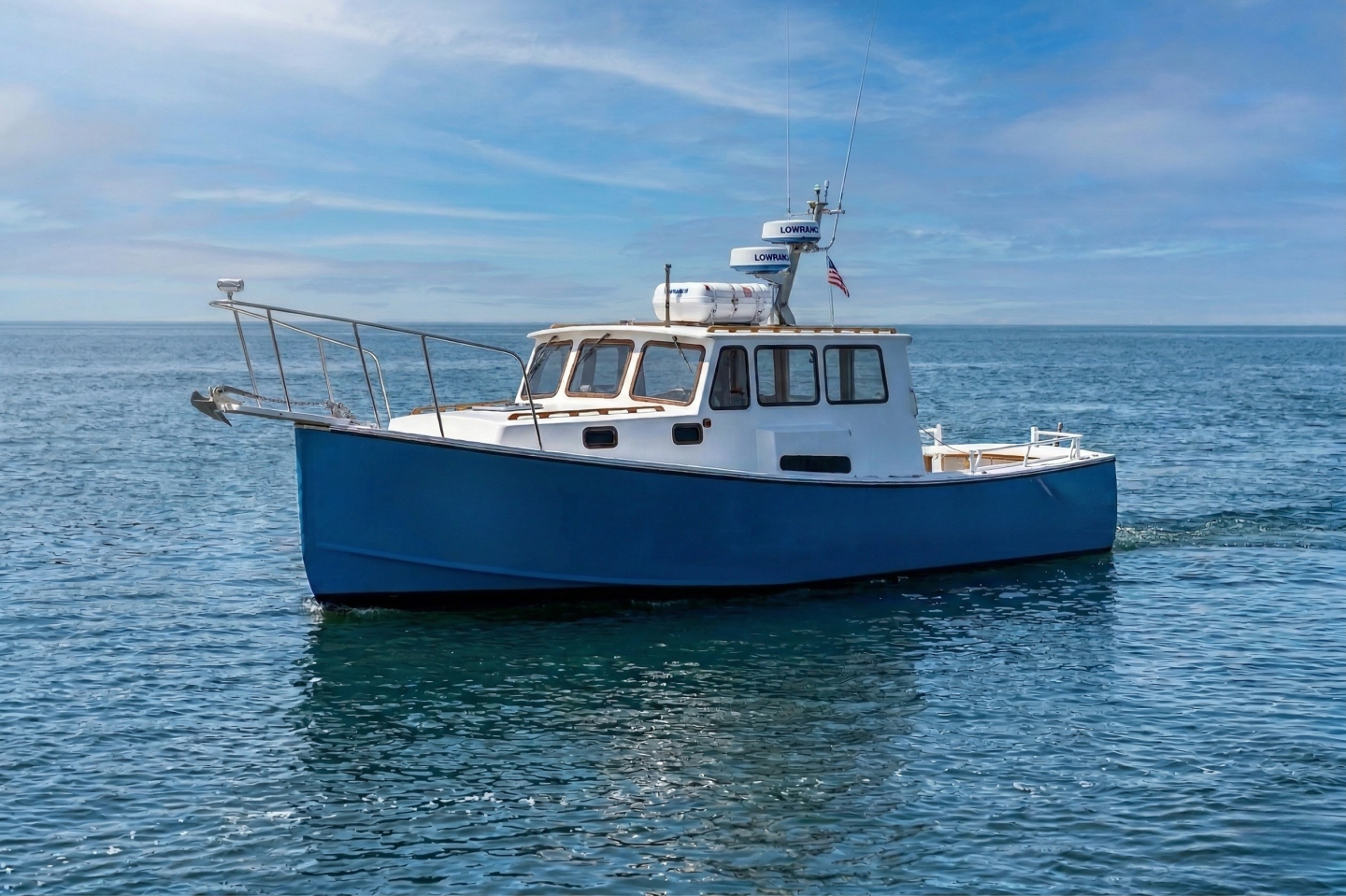Blue boat on calm ocean under a clear sky.