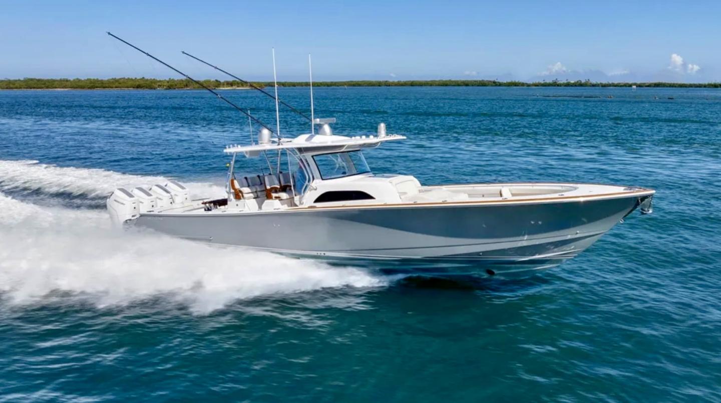 Speedboat cruising on clear blue water under a sunny sky.