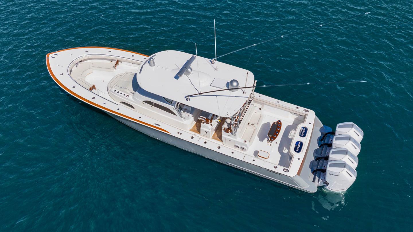 Large white yacht on calm blue water, viewed from above.