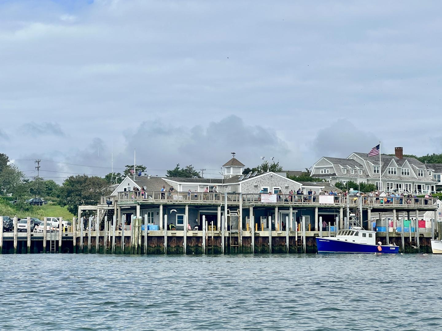 Seaside town with docks, boats, and overcast sky.