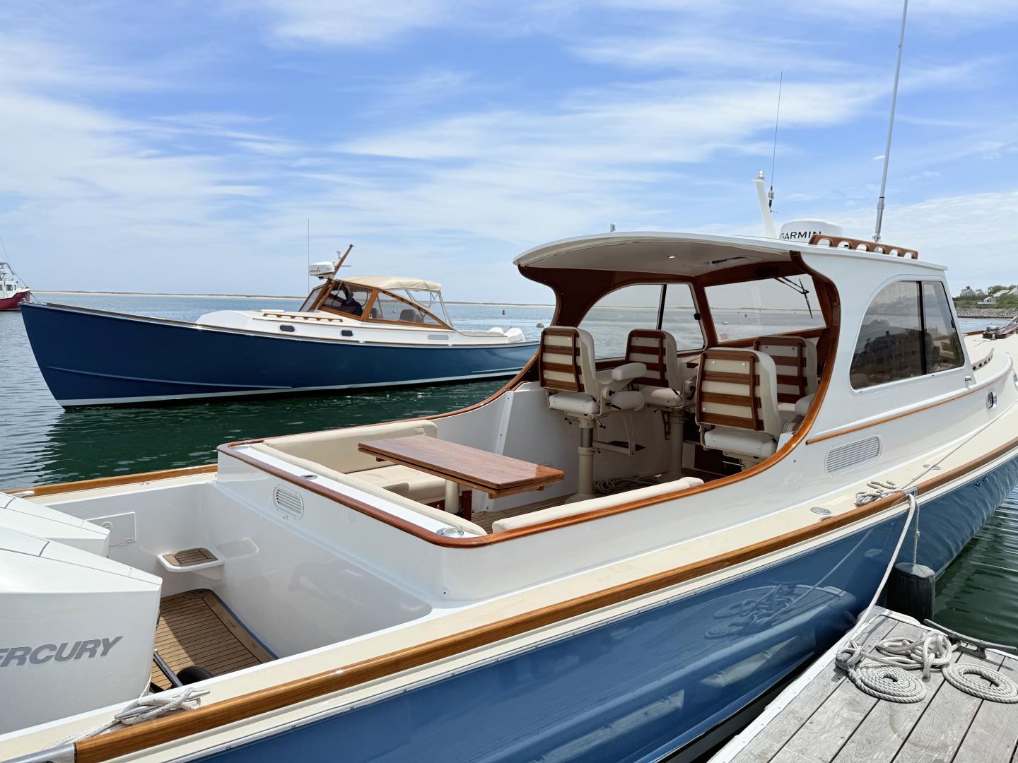 Two blue and white boats docked under a clear sky.