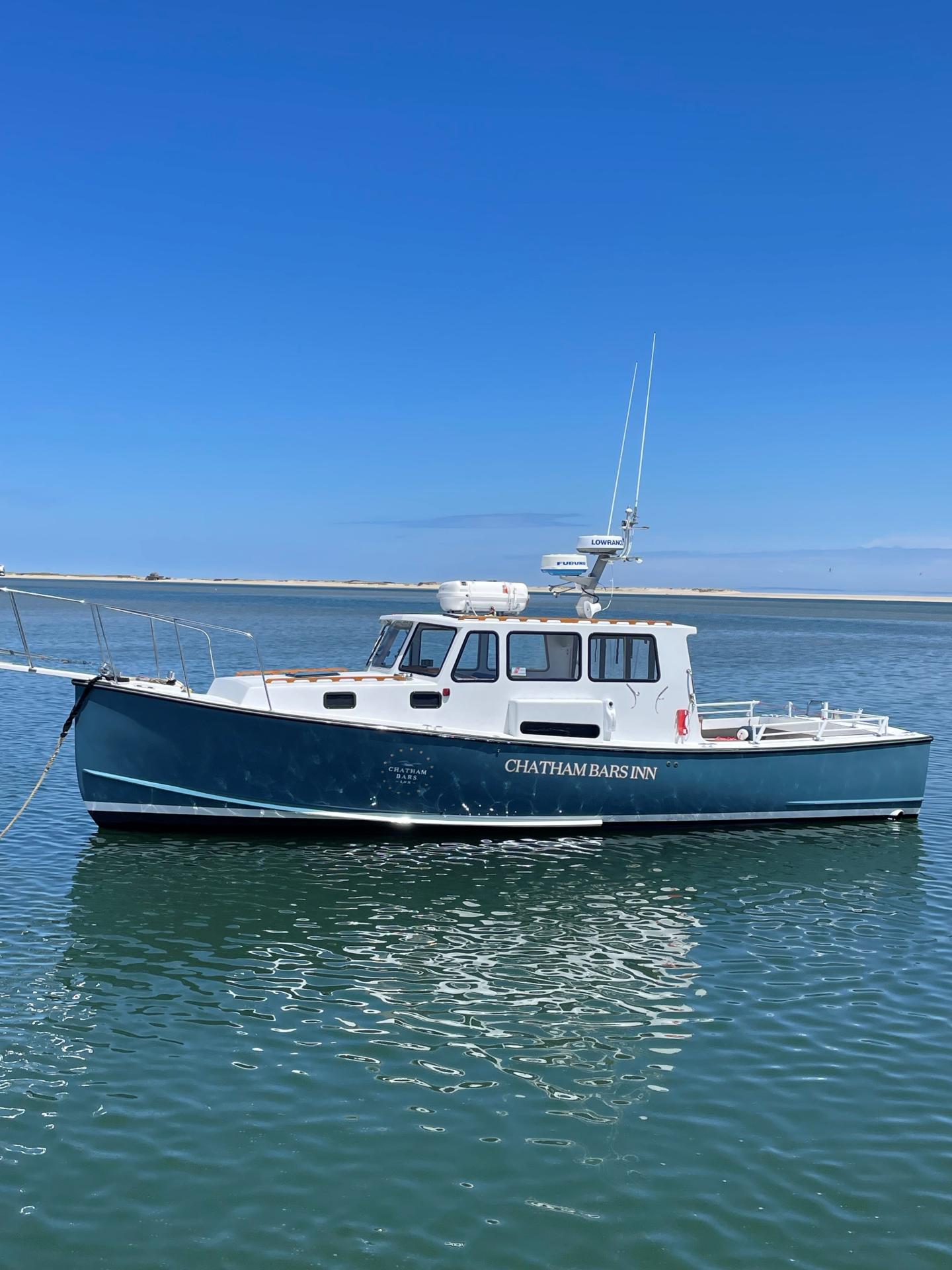 Blue fishing boat on calm water under a clear sky.